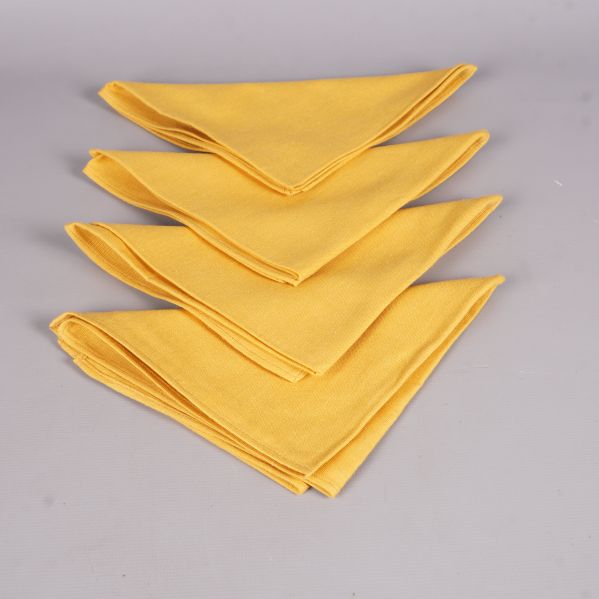 Fyra gula tygservetter lagda ovanpå varandra