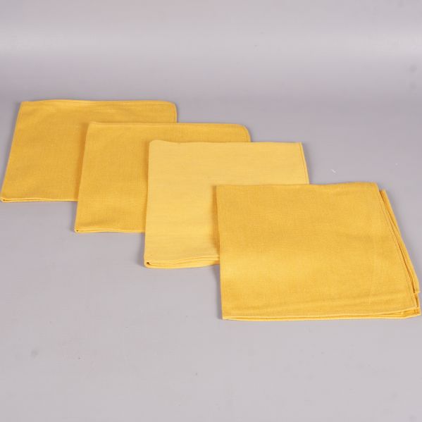 Gula tygservetter utlagda platt i en rad