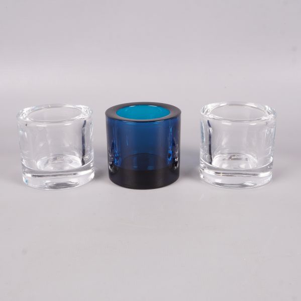 Framifrån av tre glasljushållare, en färgad