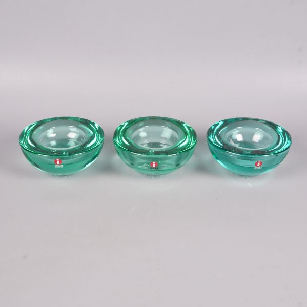 Tre runda gröna glaskandelabrar i rad