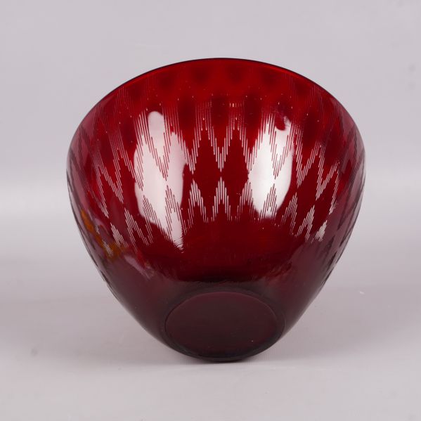 Röd skål i profil, visar mönstrad yta och djup