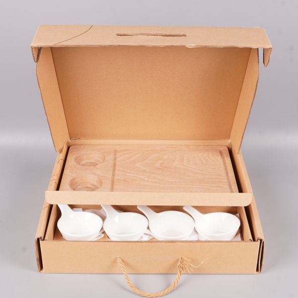 Serveringsset placerat i öppen presentkartong med handtag