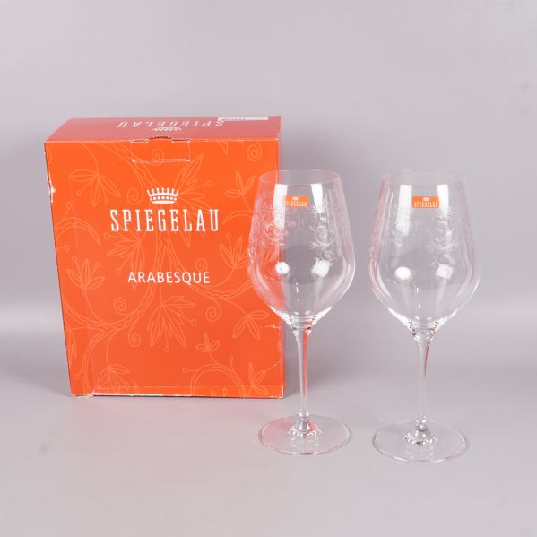 Två vinglas med graverat mönster bredvid förpackning från Spiegelau