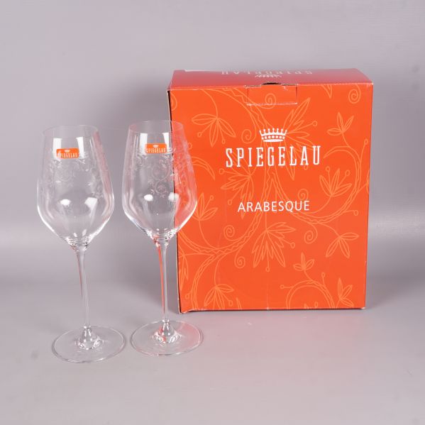 Två graverade vinglas bredvid orange förpackning från Spiegelau