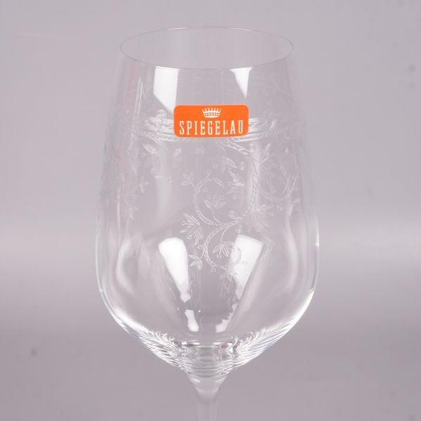 Närbild av ett vinglas med gravyr och Spiegelau-dekal