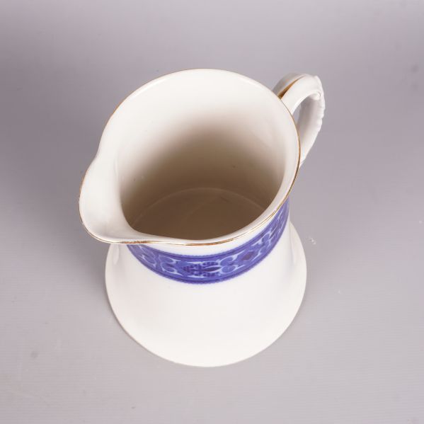 Närbild uppifrån på kanna med blå dekor vid öppningen