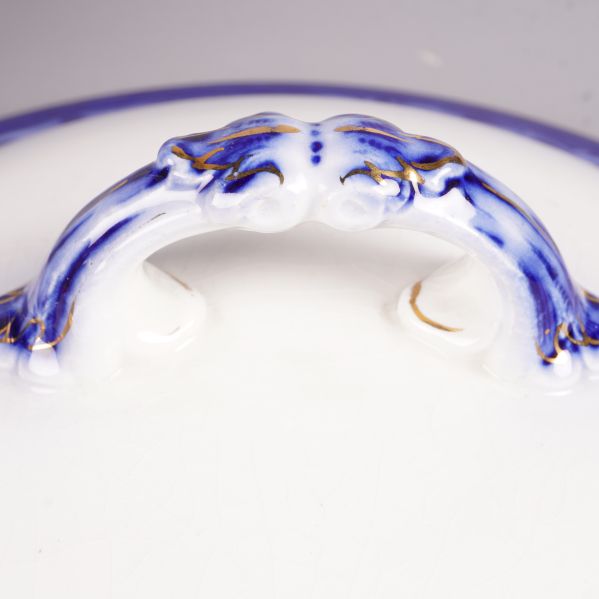 Närbild på handtaget till soppskålens lock med blå detaljer