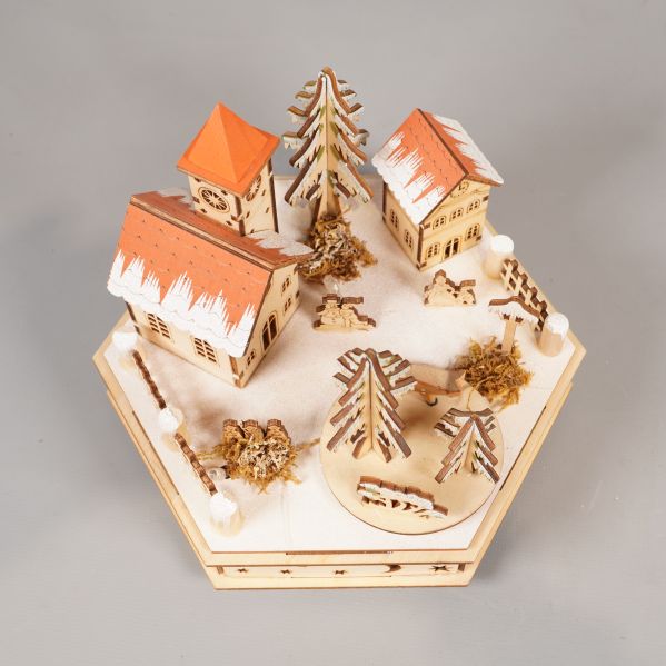 Julby i trä sedd uppifrån med granar och snöeffekt