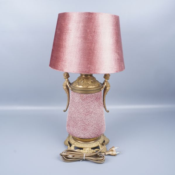 Baksida av bordslampa med synlig kabel och gulddekor
