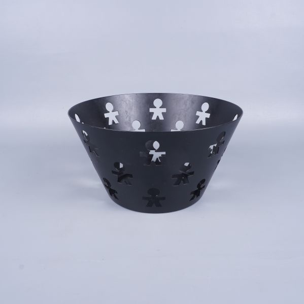 Svart fruktskål med figurutskärningar sedd framifrån