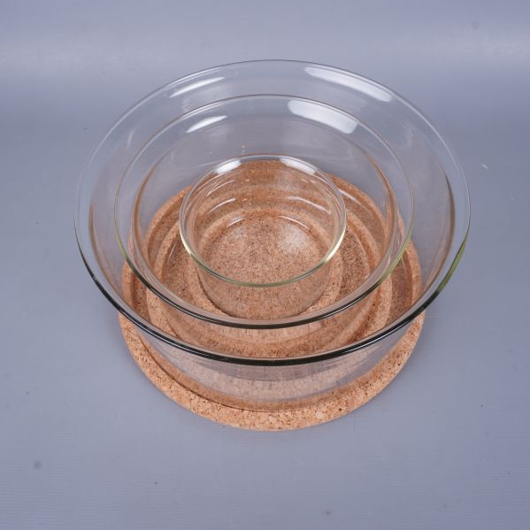 Glasskålar staplade i varandra ovanpå rund korkbricka
