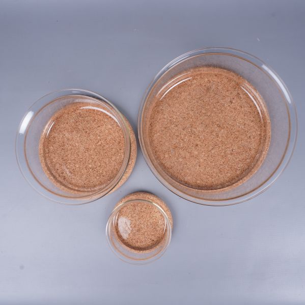 Tre glasskålar med korkunderlägg uppställda ovanifrån