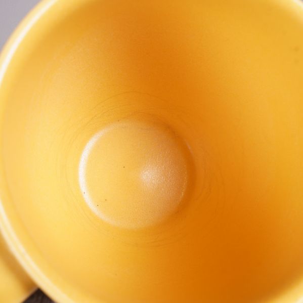 Närbild på insidan av gul mugg