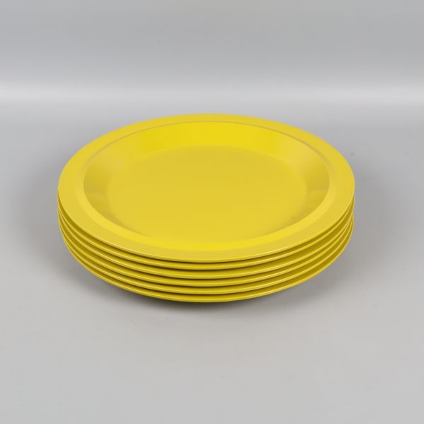 Sex gulgröna tallrikar staplade på varandra i profil