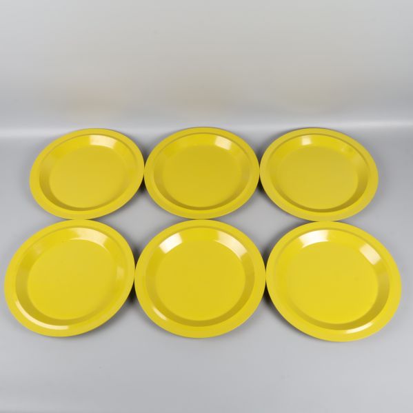 Sex gulgröna tallrikar utlagda bredvid varandra uppifrån