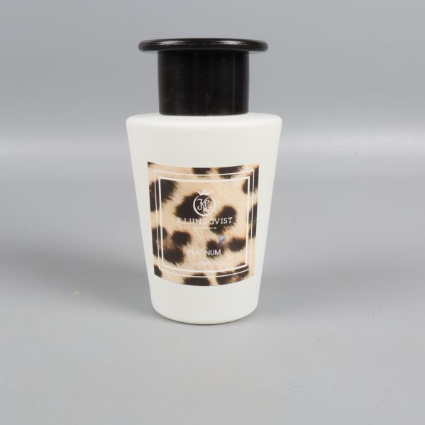 Närbild på doftflaska med svart topp och leopardmönstrad etikett