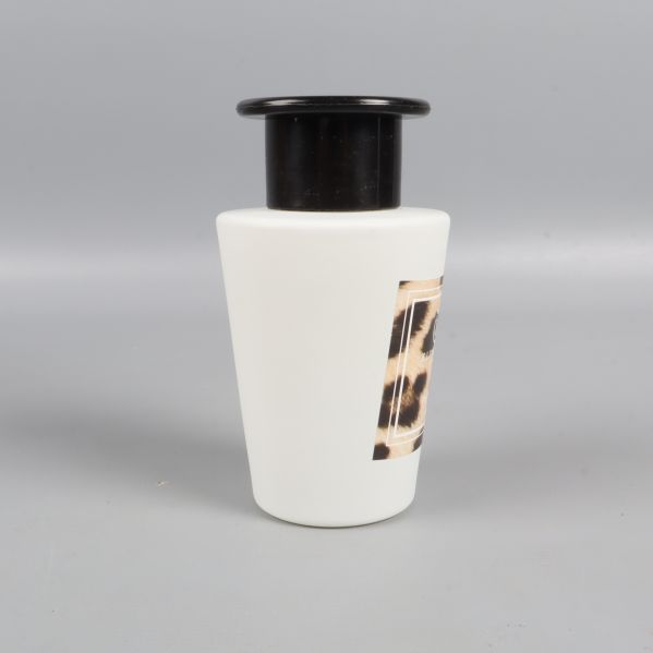 Baksida av vit doftpinnflaska med svart topp