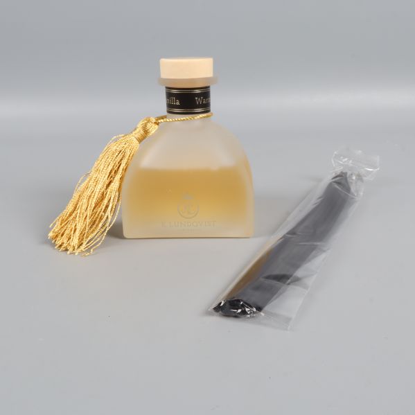 Doftpinnar bredvid frostad flaska och tofs