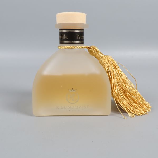 Framsida på frostad glasflaska med guldfärgad tofs