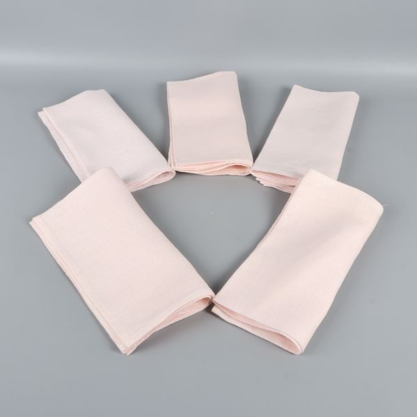 Fem vikta ljusa tygservetter upplagda i en cirkel