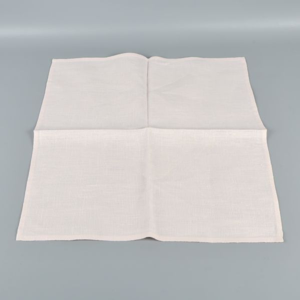 En helt utvikd kvadratisk ljus tygservett mot grå bakgrund