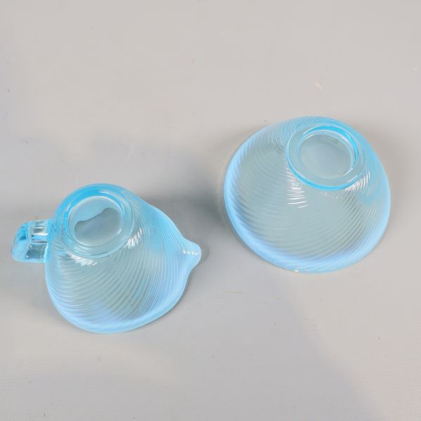 Botten på gräddkanna och sockerskål i blått glas