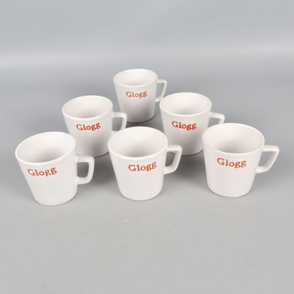 Sex vita glöggmuggar med röd text arrangerade framför grå bakgrund