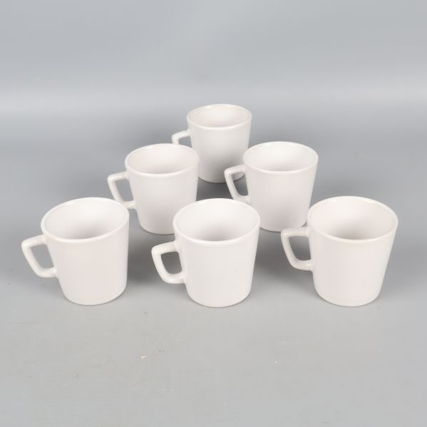 Baksidan av sex vita glöggmuggar visas mot grå bakgrund