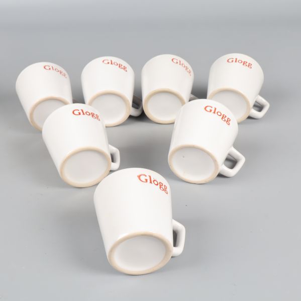 Sju vita muggar med röd text 'Glögg' placerade på sidan