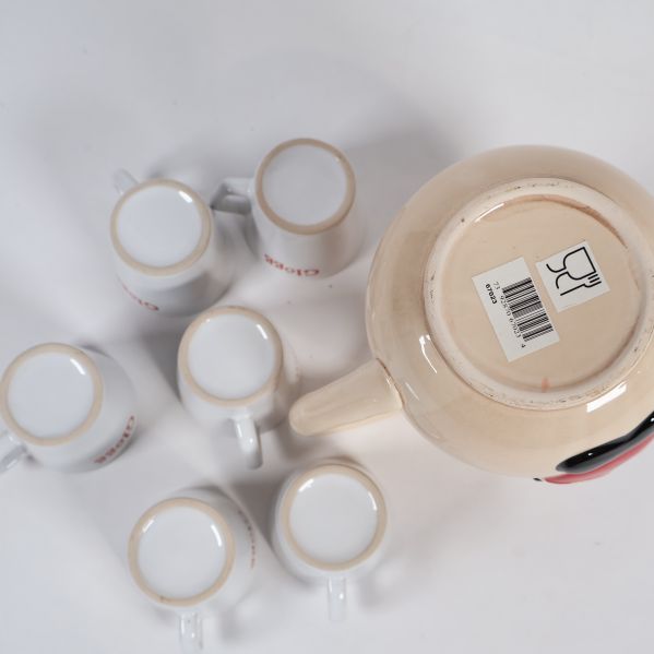 Kannans botten med etikett samt sex vita glöggmuggar