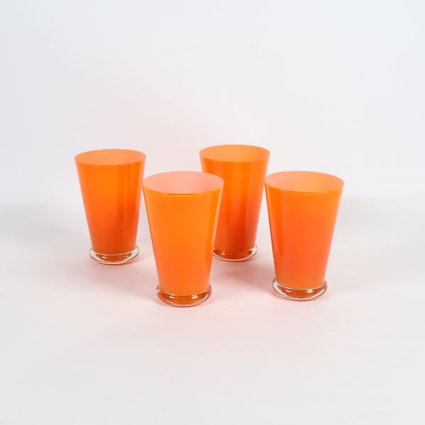 Fyra orange dricksglas med runda klara bottnar