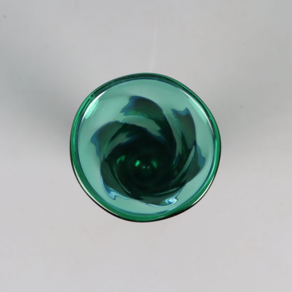 Öppningen på vasen med svepande grönt glas i närbild
