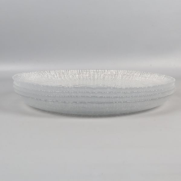 Fyra staplade stora tallrikar av transparent glas