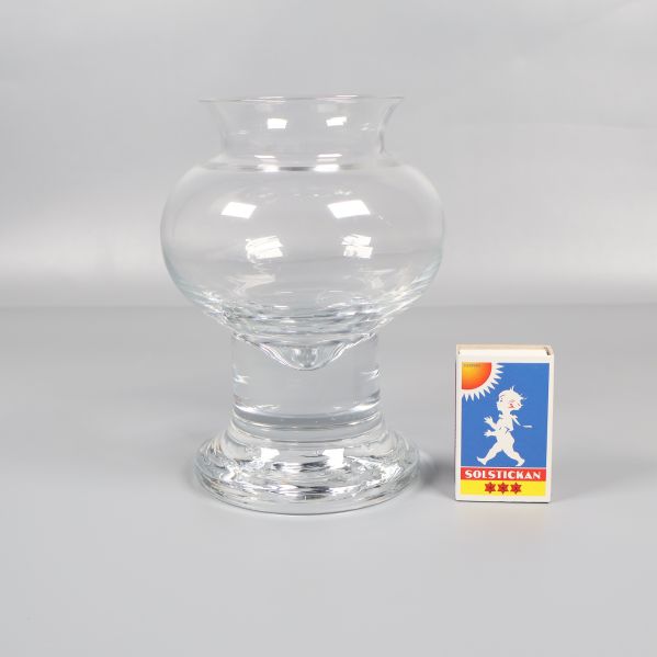 Glasljusstake bredvid tändsticksask för storleksjämförelse