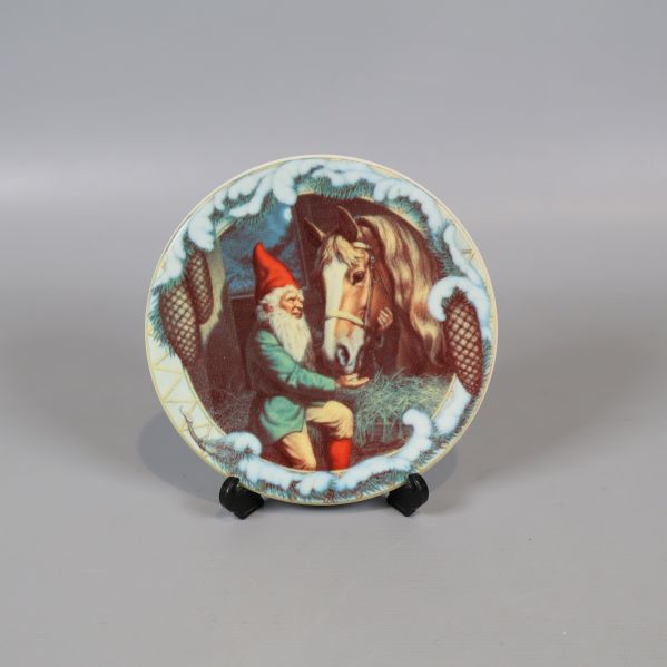 Tallrik med tomte och hästmotiv på svart ställning
