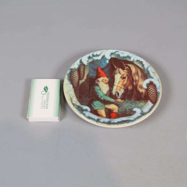 Tallrik med tomtemotiv brevid tändsticksask för storleksreferens