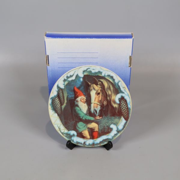 Jultallrik med tomtemotiv visas framför blå förpackning