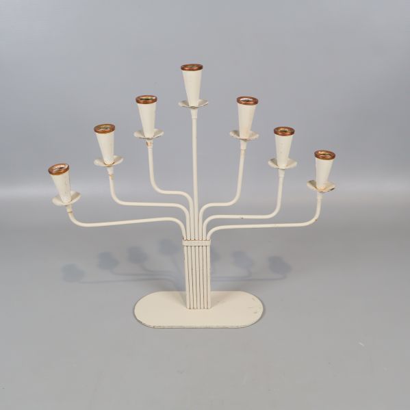 Vit sjuarmad ljusstake stående på grå bakgrund