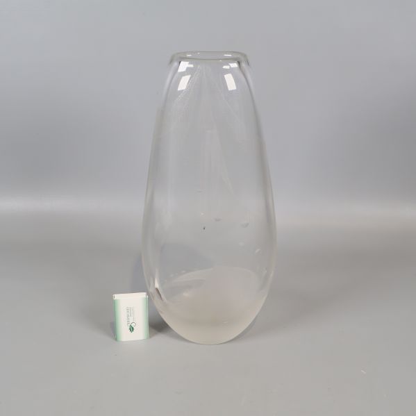 Transparent vas bredvid en liten tändsticksask för storleksjämförelse