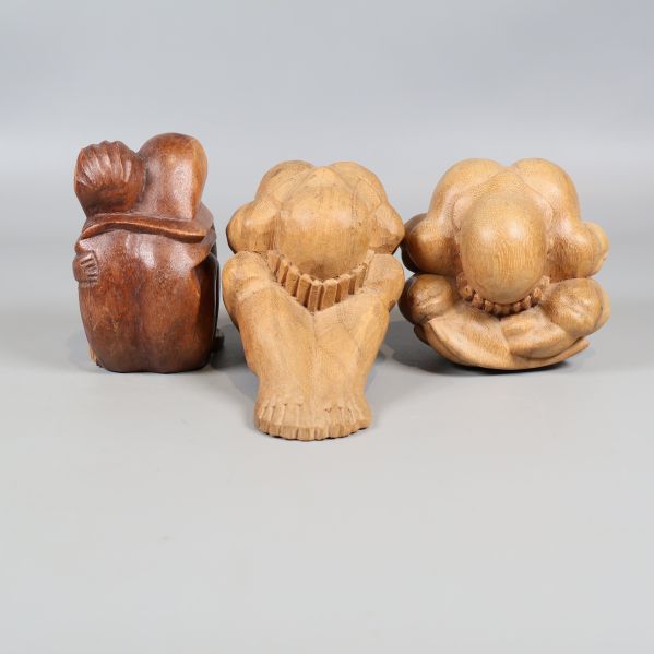 Tre sittande träskulpturer med olika former