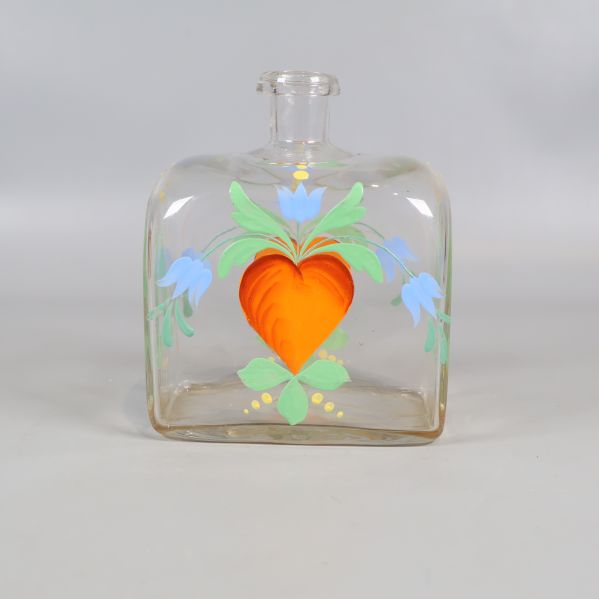 Framifrån vy av snapskaraff med hjärtmotiv och blommor