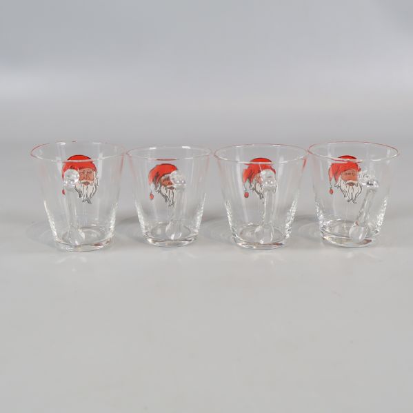 Frontal vy av fyra tomteprydda glögglas på rad