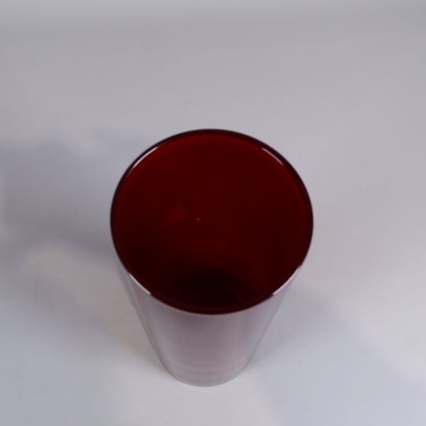 Röd cylinderformad vas fotad uppifrån med synlig insida