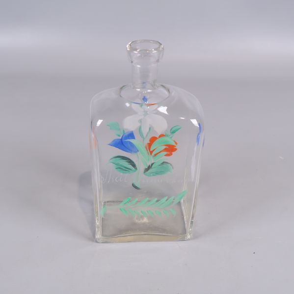 Klar glasflaska med målad dekor av blommor framtill