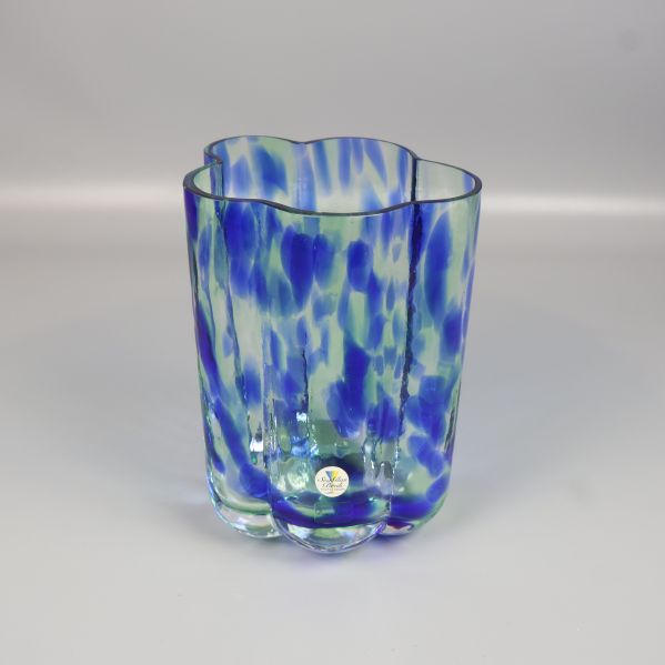 Vas i blått glas med gröna och vita inslag sedd framifrån