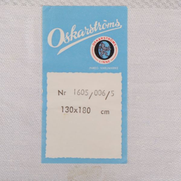 Närbild på etikett från Oskarströms med mått 130x180 cm