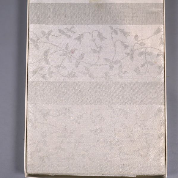 Närbild på linneduken med diskret blommönster