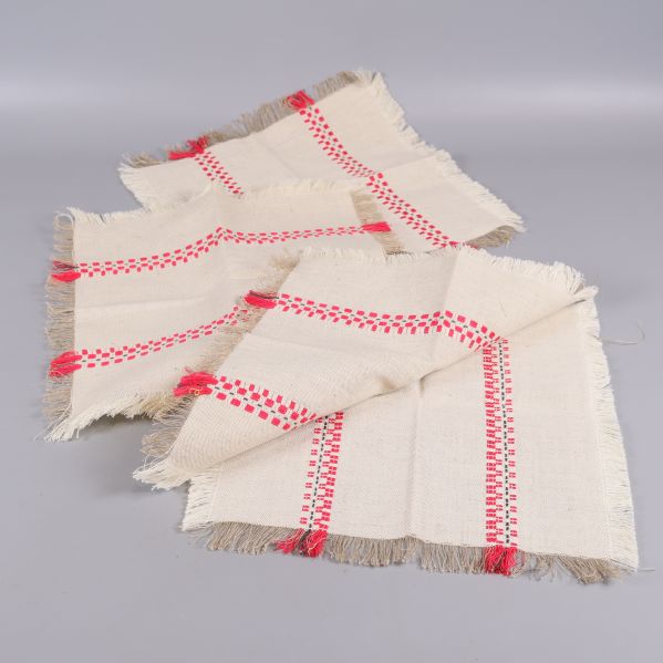 Tre tygservetter utspridda med röda mönster