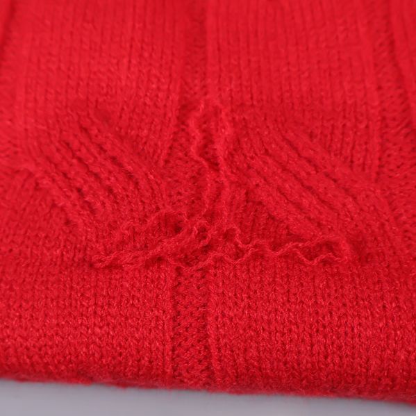 Närbild visar slitning och trådskada på röd pläd