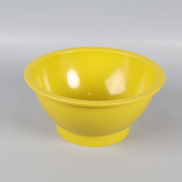 Gul/Grön skål i plast med rundad form fotograferad snett framifrån